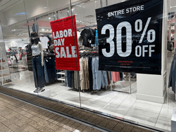 Signs announce a Labor Day sale in the window of a clothing store at a mall in Denver on Aug. 21, 2024. (AP Photo/David Zalubowski, File)