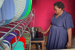 Mary Kavutha prepares breakfast using a fuel-efficient cookstove made by BURN in Kiambu, Kenya, on July 31, 2026. (AP Photo/Allan Olingo)