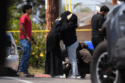 People embrace near the scene of a shooting outside the Islamic Center in San Diego, May 18, 2026, (AP Photo/Gregory Bull, File)