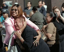 Two women embrace each other as they watch the World Trade Center burn following a terrorist attack on the twin skyscrapers in New York, Sept. 11, 2001. (AP Photo/Ernesto Mora, File)
