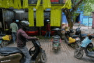 Delivery workers and drivers arrive at a battery-swapping station for electric vehicles in New Delhi, India, Monday, July 13, 2026. (AP Photo/Manish Swarup)