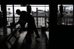 A Haitian worker with Temporary Protected Status cleans and busses tables at Half Shell Raw Bar, Friday, July 24, 2026, in Key West, Fla. (AP Photo/Rebecca Blackwell)