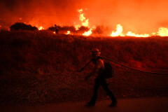 A firefighter monitors flames caused by the Hughes Fire along Castaic Lake in Castaic, Calif., Jan. 22, 2025. (AP Photo/Jae C. Hong, File)