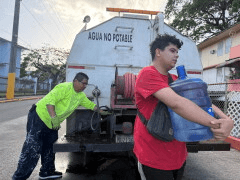 Bryan Pérez hauls a five-gallon water jug to his apartment in the Villa Kennedy public housing complex in San Juan, Puerto Rico, Wednesday, June 10, 2026. (AP Photo/Danica Coto)