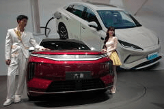 Models stand next to a latest EV car from Chinese automaker BYD showcased at the Auto China 2026, in Beijing, April 25, 2026. (AP Photo/Andy Wong, File)
